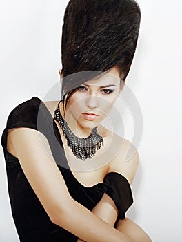Sentiment. Pensive Bright Woman with Black Updo Hair and Necklace
