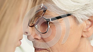 Sentimental forehead touch of young and senior woman. Close up