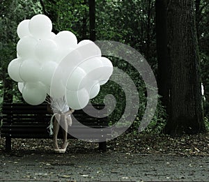 Sentimentality. Nostalgia. Lonely Woman with Air Balloons sitting on Bench in the Park