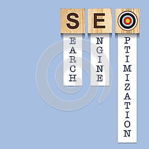 SEO concept. Search engine optimization. Word on wooden blocks, over blue background