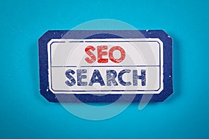 SEO, SEARCH concept. Text on a sheet of paper. Blue textured background