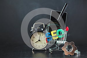 SEO Search engine optimization concept Colored letters of SEO with clock, magnifying , smartphone, gears in a basket on a black ba