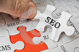 SEO Search engine optimization concept. Man is solving puzzle