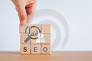 SEO, Search Engine Optimization ranking concept. Digital marketing strategy of promote website. Hand holds wooden cubes with graph