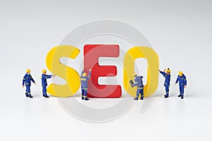 SEO, Search Engine Optimization ranking concept, miniature people figure workers team building alphabets abbreviation SEO on whit