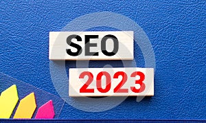 SEO 2023. text on a notebook and on wooden blocks.