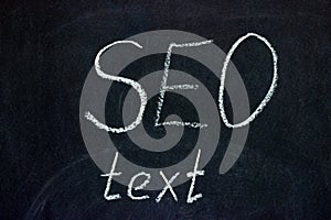 SEO text phrase on dark chalk board. Copywriting activity