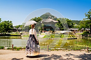 Seoul, South Korea. Hanbok wearing woman. Gyeongbokgung palace park garden. Korean dress tradition. Hyangwonjeong Pavilion.