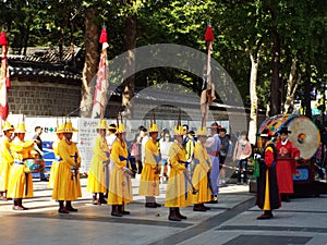 Musicians in yellow uniform in front of a large drum at the changing of the Royal Guard ceremony at Deoksugung Palace in Seoul