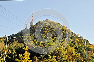 SEOUL, SOUTH KOREA - OCTOBER 23, 2022: N Seoul Tourist Sigthseeing tall tower above Namsan mountain hill and blue sky with Autumn