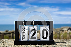 Sep 20 calendar date text on wooden frame with blurred background of ocean.