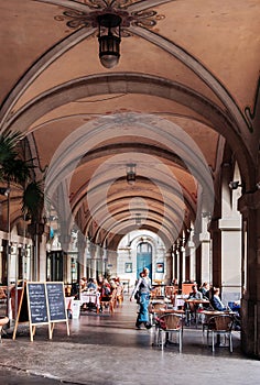 Street restaurant dinner table under arch arcade with sunlight i