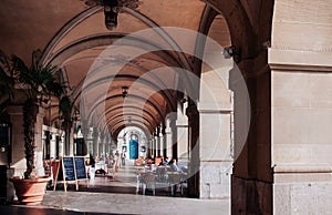 Street restaurant dinner table under arch arcade with sunlight i
