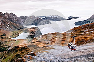 Ropeway Gondola lift flying over cloud and alpine mountain valley of Titlis in Engelberg, Switzerland