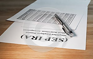 SEP IRA paper document on wood table with pen and calculations