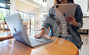 Sep 21th 2020 : A woman using Apple New Ipad Pro 2020 digital tablet with Apple MacBook Pro laptop computer on wooden