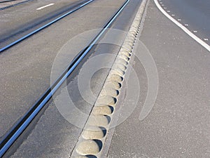 Separation barrier between tram tracks and car road