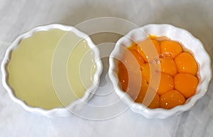 Separeted yolk and eggwhites in bowls on a table
