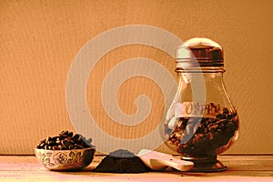 SEPIA HUED PRESENTATION OF ROASTED COFFEE BEANS AND GROUNDS ON A TABLE TOP