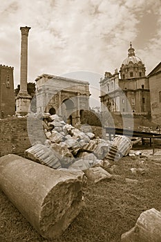 Sepia image of Roman ruins with Column of Foca with Roman Forum in background in Rome, Italy, Europe