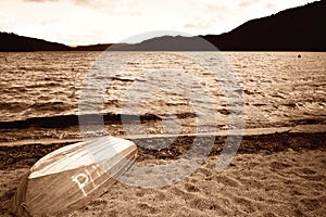 Sepia of an old lake boat waiting to be used on this windy lake