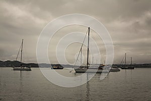 Sepia retro photo of sailing boats waiting out stormy weather in a small harbour