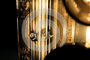 Sepia Toned Abstract Macro Closeup of Grooves on Bottom of See Through Cassette Tape Standing on Side With Reels Visible