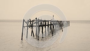 A Sepia toned photo of an old wooden jetty at Bophut beach in Koh Samui, Thailand.
