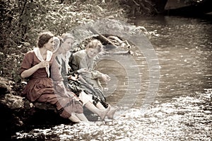 Sepia women by river creek in civil war reenactmen