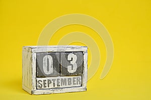 September 03 wooden calendar standing yellow background with an empty space for text.