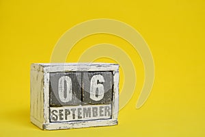 September 06 wooden calendar standing yellow background with an empty space for text.