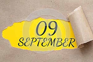 september 09. 09th day of the month, calendar date.Hole in paper with edges torn off. Yellow background is visible