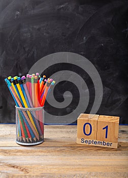 September 1st date and colorful pencils on blackboard background, space for text