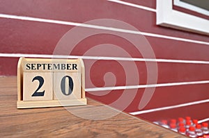 September 20, Number cube with a red wall background.