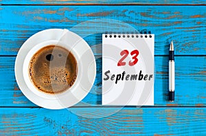 September 23rd. Day 23 of month, loose-leaf calendar and cappuccino cup Customer Services Assistant workplace background