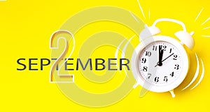 September 2nd. Day 2 of month, Calendar date. White alarm clock with calendar day on yellow background. Minimalistic concept of