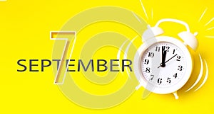September 7th. Day 7 of month, Calendar date. White alarm clock with calendar day on yellow background. Minimalistic concept of