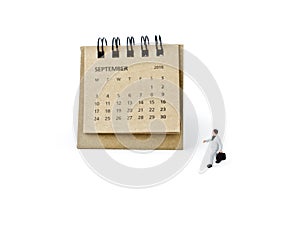 September. Calendar sheet and miniature plastic businessman on w