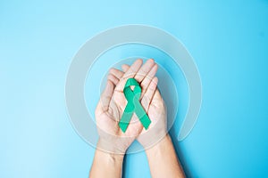 September Ovarian cancer Awareness month, Woman holding teal Ribbon color on blue background for supporting people living, and
