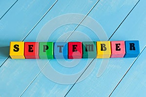 September sign on color wooden cubes with light