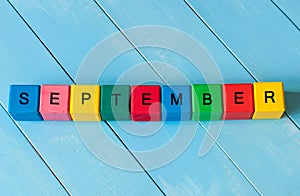 September sign on color wooden cubes with light