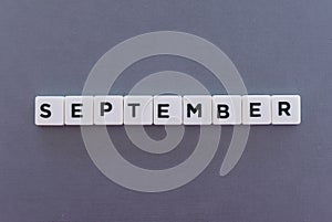 September word made of square letter word on grey background