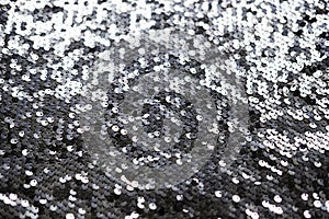 Sequin fabric texture. Shiny silver sparkling background. Clothing piece of glitter metallic for a glamorous party