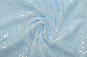 Sequinned textile has light blue colour, cloth textured backgrounds, azure drapery spangle  fabric, glamour bright material, shine