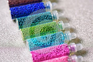 Sequins in bottles for the design of nails on a light background