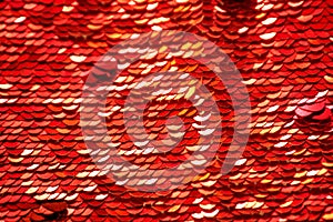 Sequins close-up macro. Abstract background with red sequins. Texture scales of round sequins.