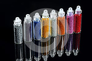 Sequins nail in bottles on a black background