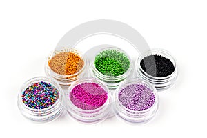 Sequins for nails of different colors in an assortment in boxes on a white background