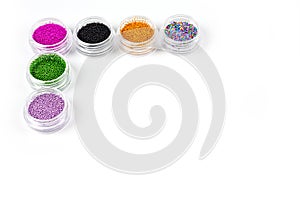 Sequins for nails of different colors in an assortment in boxes on a white background