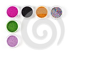 Sequins for nails of different colors in an assortment in boxes on a white background